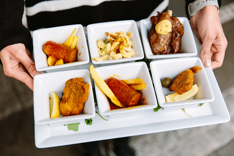 Plate with samples of Berlin street food including currywurst, spaetzle, and french fries.