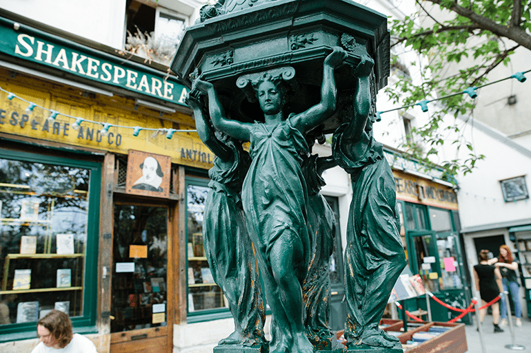 Close up of a Wallace fountain, small cast-iron sculptures that are also public drinking water fountains in Paris, France, just outside Shakespeare and Company bookstore.