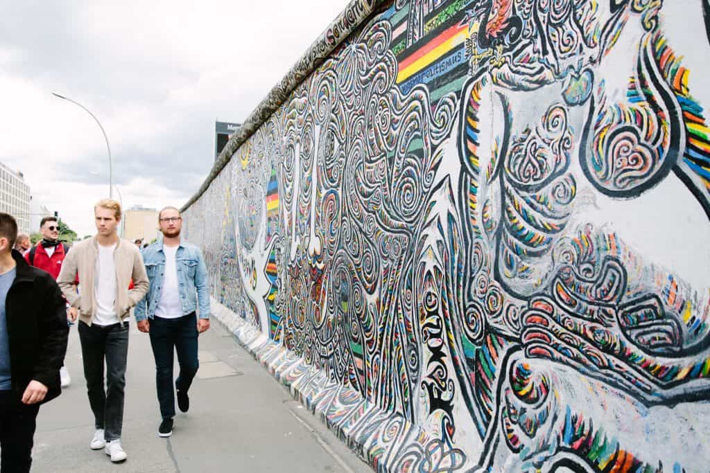 People walk alongside the colorful East Side Gallery in Berlin, a stretch of remains from the Berlin wall that have been transformed into public murals.