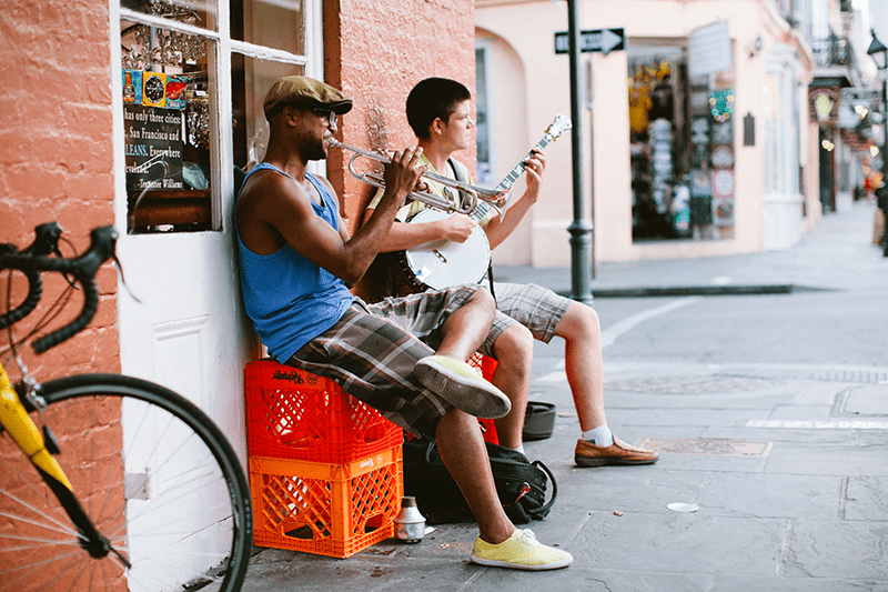 Two men play instruments on the streets in New Orleans.