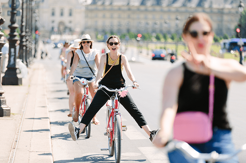 A woman poses while riding a bicycle in Paris, France