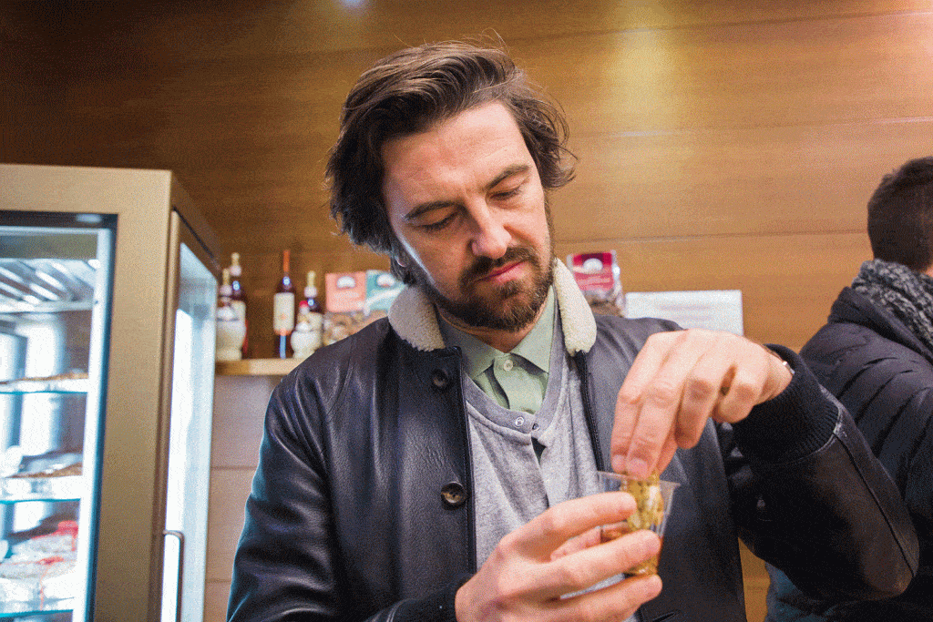 man dipping biscuit in alcohol in italy