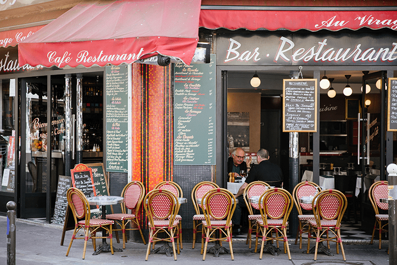 Tables and chairs outside on the terrace of a classic French bistro in Paris, France