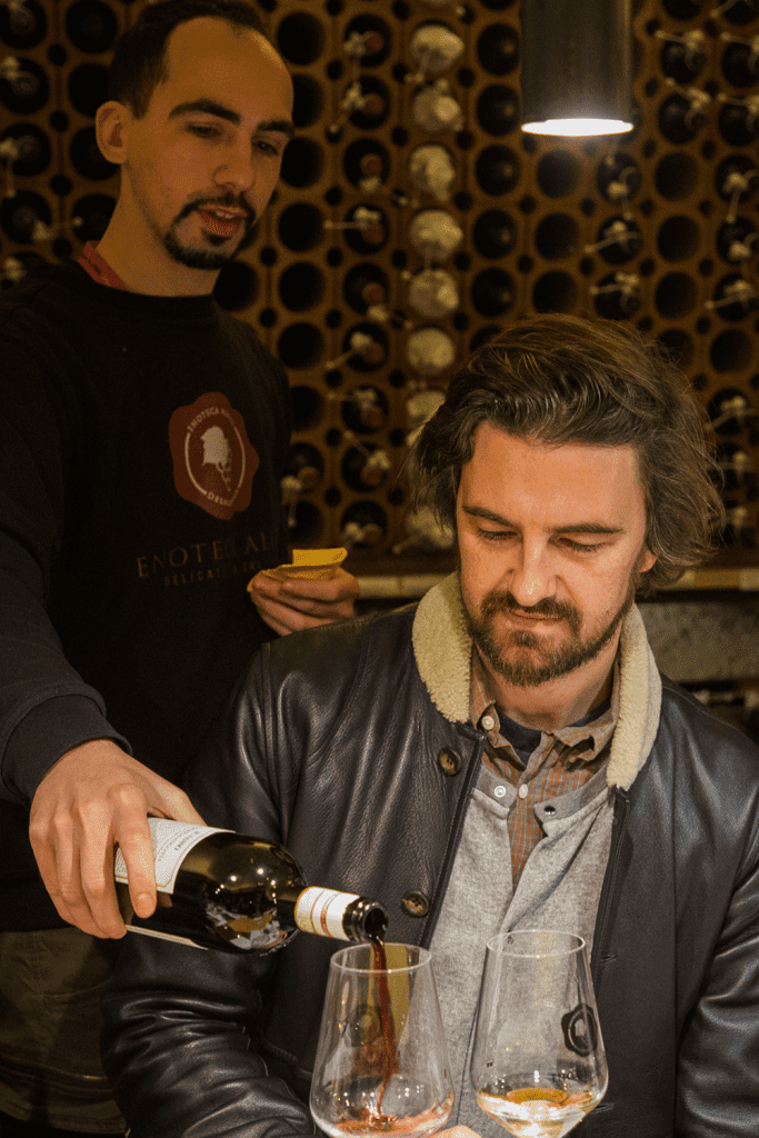 man being served wine in florence, italy