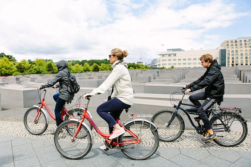 People bike along the Memorial to the Murdered Jews of Europe in Berlin, Germany