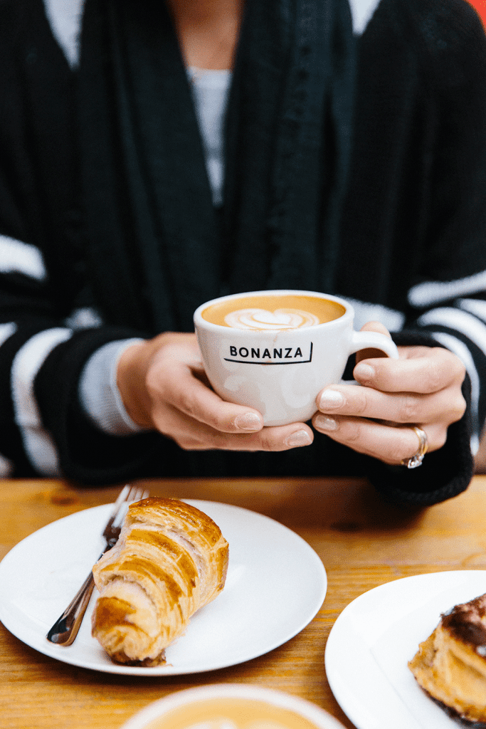 someone holding up a latte from bonanza in berlin