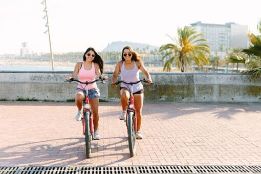 Two girls with bikes along the Barceloneta Beach