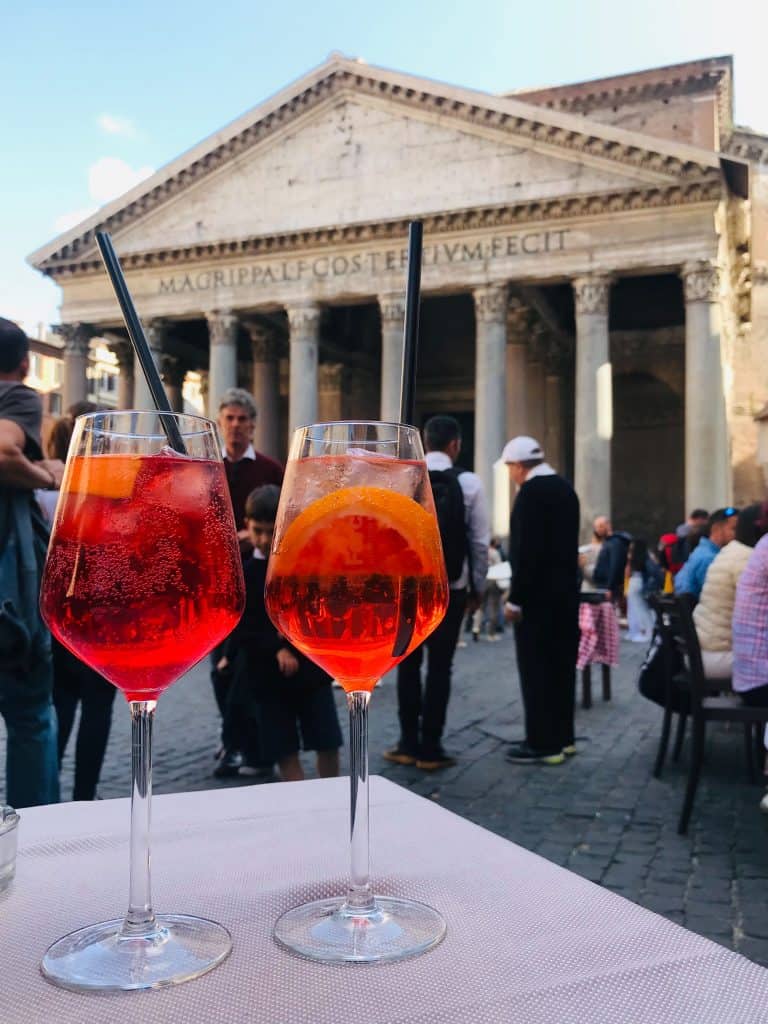 Two glasses of Aperol Spritz with views of the Pantheon in Rome, Italy