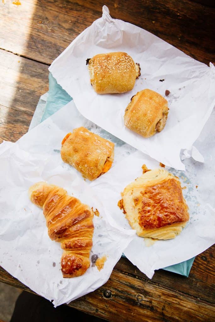 A variety of French croissants on a table in Paris, France including a traditional croissant au burre, pain au chocolate, and more