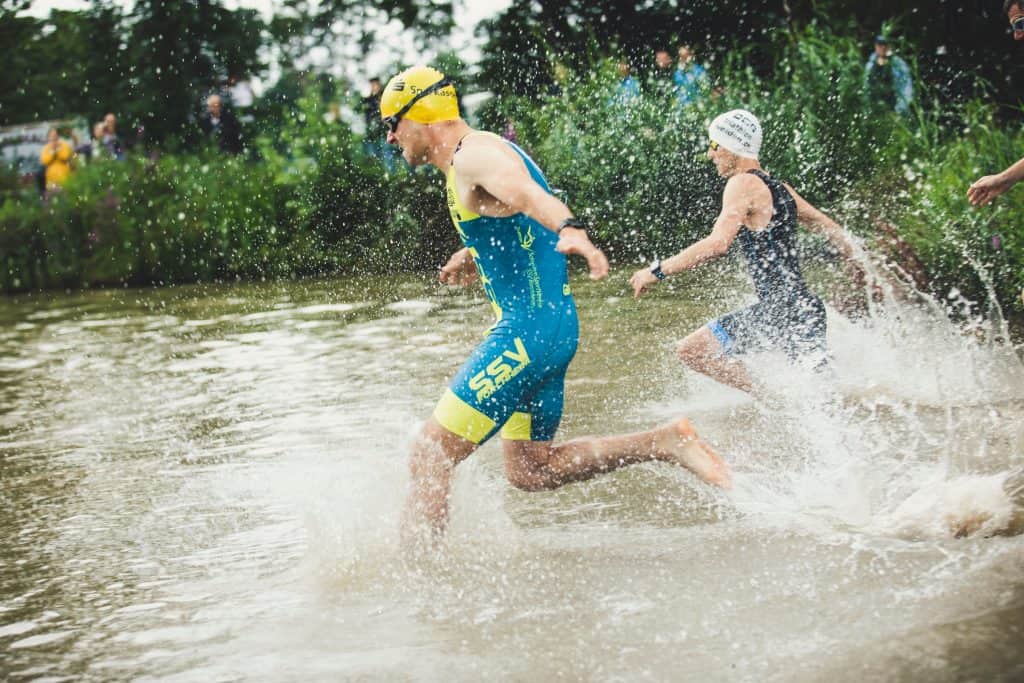 swimmers running into the water during the triathlon paris olympics