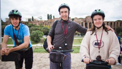 A family smiles for a photo while riding Segways in Rome, Italy