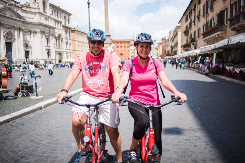 A couple poses for a photo on their bikes in Rome, Italy