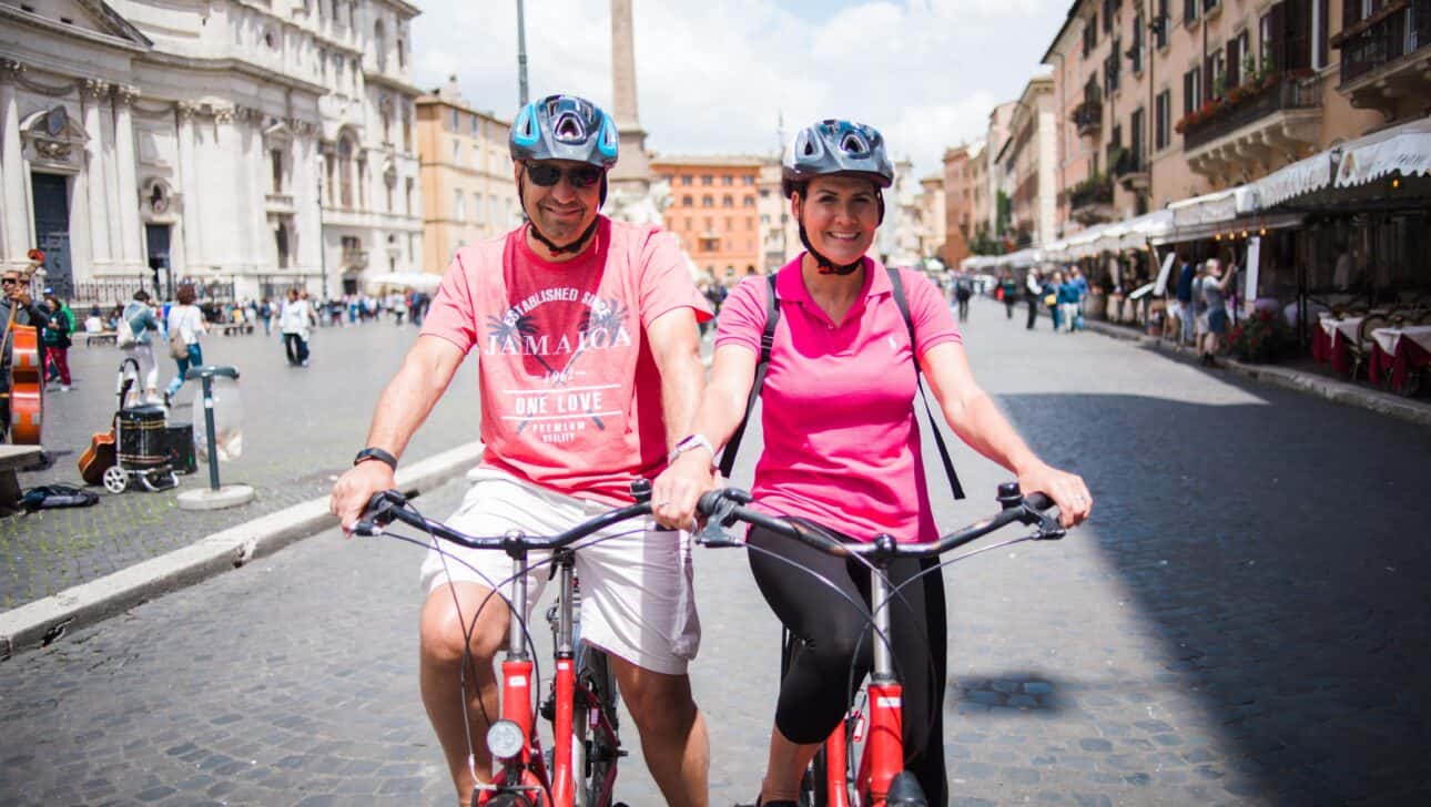 A couple poses for a photo on their bikes in Rome, Italy