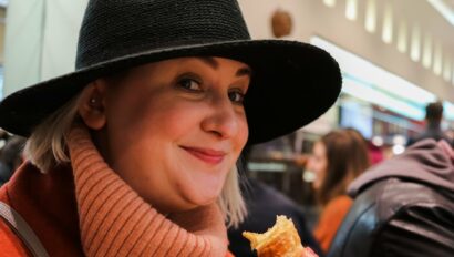 A woman smiles as she enjoys an Italian pastry in Milan