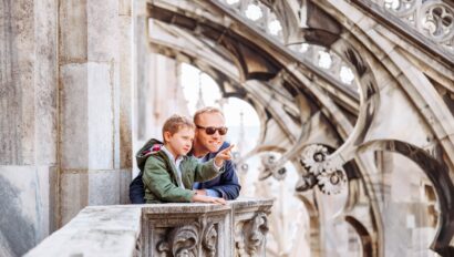 A father and son look out over Milan from the rooftop of the Cathedral in Milan, Italy