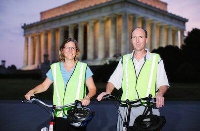 two people on bikes in front of the lincoln memorial