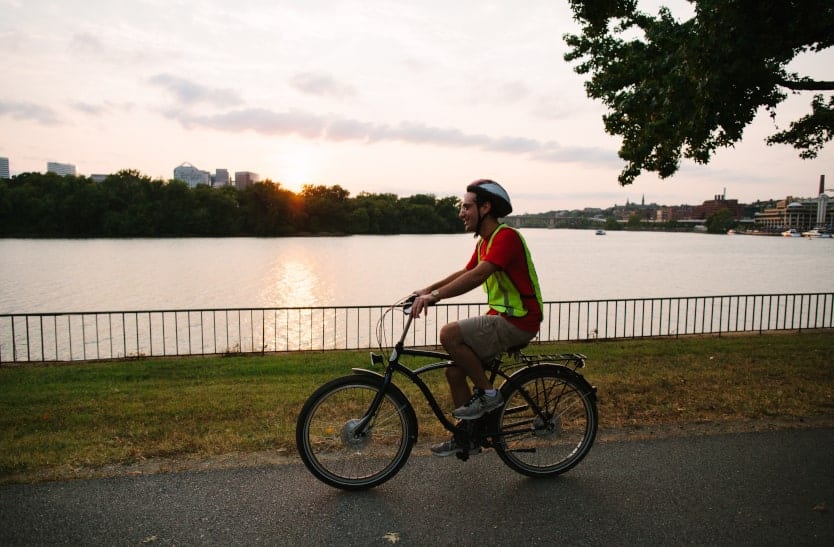 a man rides along the potomac river in the evening a the sun is setting in washington dc