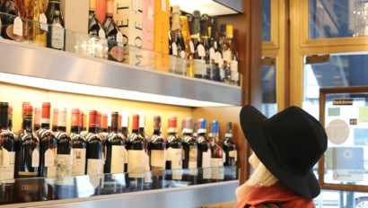 A woman admires a wine display in a shop in Milan, Italy