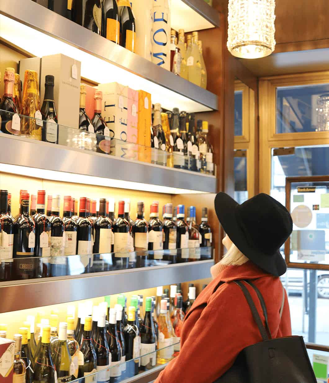 A woman admires a wine display in a shop in Milan, Italy