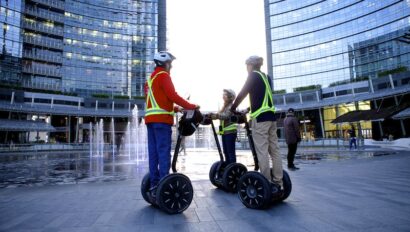 A group rides Segways through Milan's business district as the sun sets; Milan, Italy