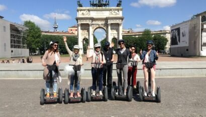 A group waves while riding Segways in front of Porta Sempione in Milan, Italy