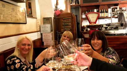Three women cheers their wine glasses in Milan, Italy
