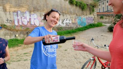 The guide pours a glass of wine along the Arno riverbank in Florence, Italy