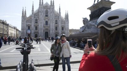 Two women pose for a photo in front of the Duomo next to their Segways in Milan, Italy