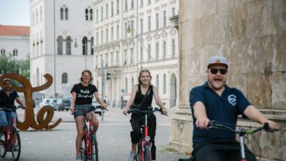 The group rides by the 'Love' sculpture in Munich, Germany