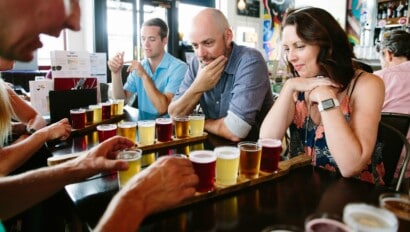 A couple looks at a flight of beer as the guide explains it in London, England