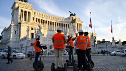 A group rides Segways in the evening in front of the Altar of the Fatherland in Rome, Italy