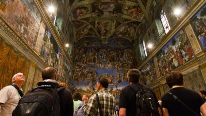A group looks up at the ceiling in the Sistine Chapel inside the Vatican in Rome, Italy
