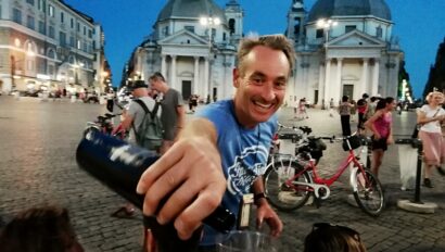 The guide pours wine in front of the Santa Maria churches in Rome, Italy