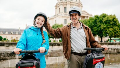 A father and daughter pose on Segways in front of Les Invalides in Paris, France