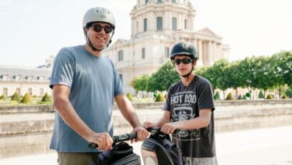 A father and son ride Segways in front of Les Invalides in Paris, France
