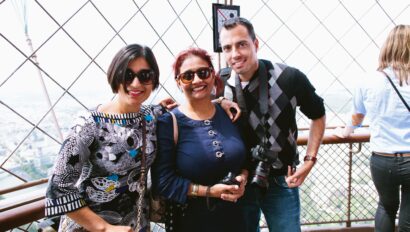 A group smiles for a photo on the Eiffel Tower in Paris, France