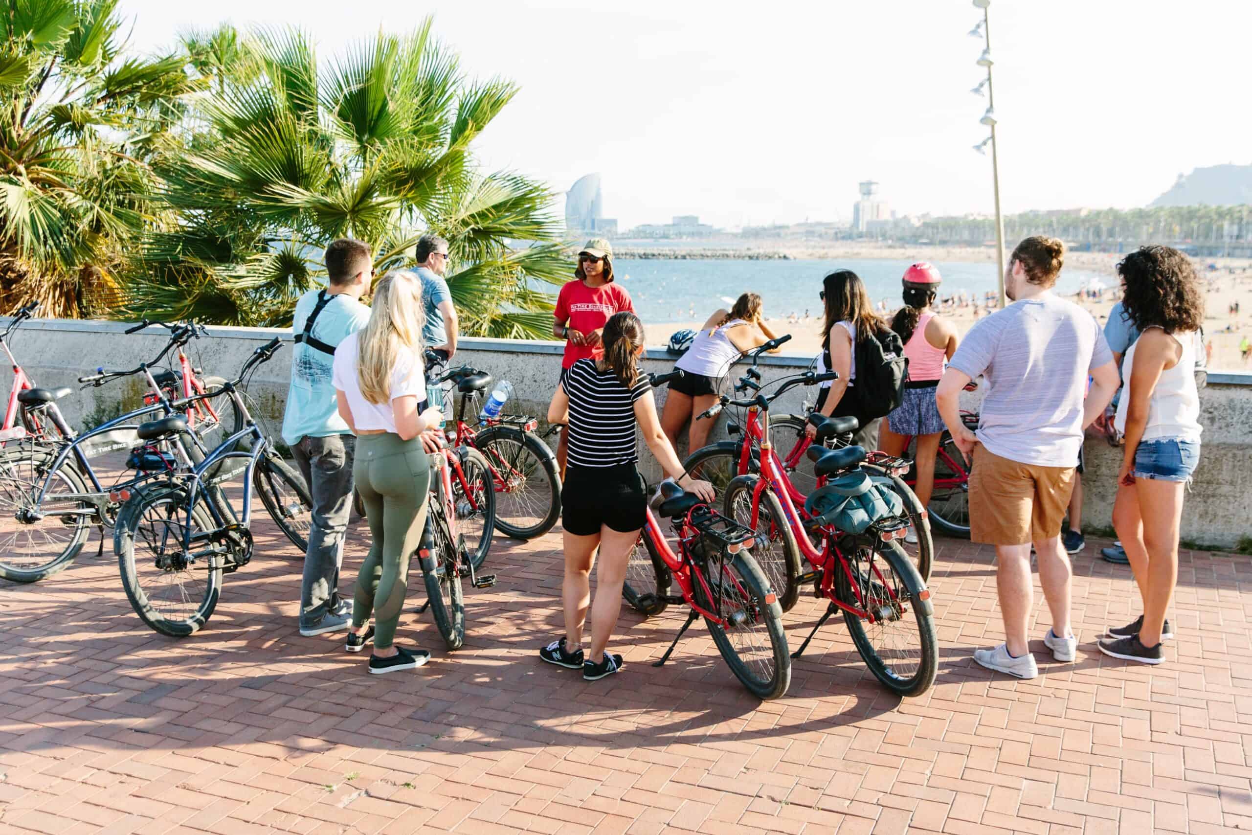 A group listens to the guide with their bikes at the end of the Barceloneta Beach