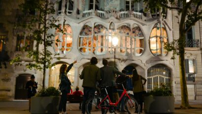 A group admires Gaudí architecture at night in Barcelona, Spain