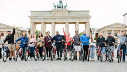 A group poses with their bikes in front of the Brandenburg Gate in Berlin, Germany