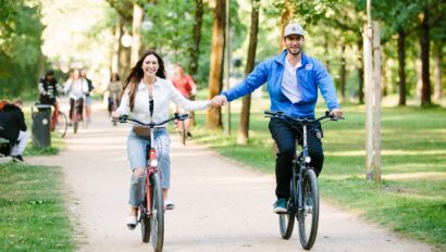 Two people hold hands while riding through the Tiergarten in Berlin, Germany