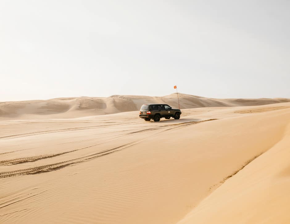 a 4x4 vehicle driving through the desert in Newcastle, Australia