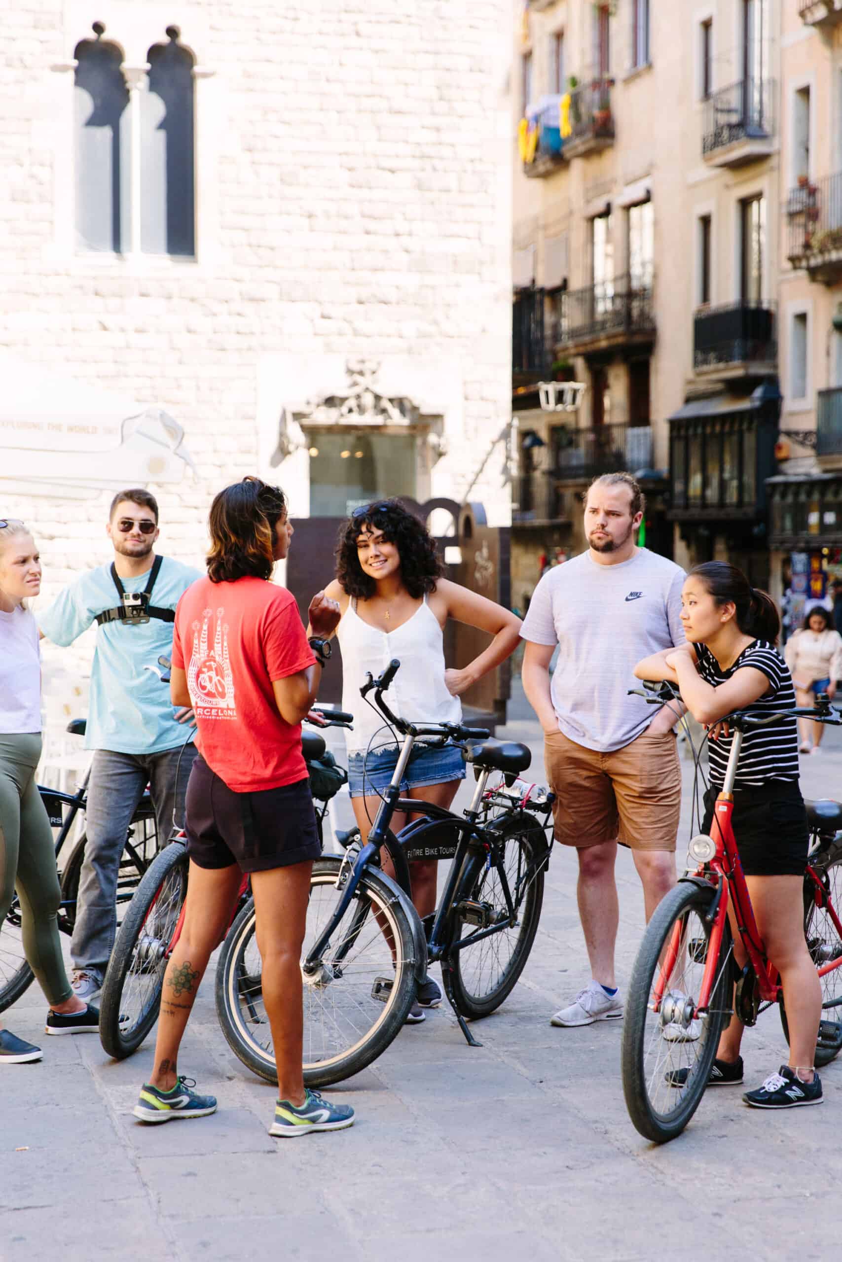 A group listens to the guide with their bikes in Barcelona, Spain