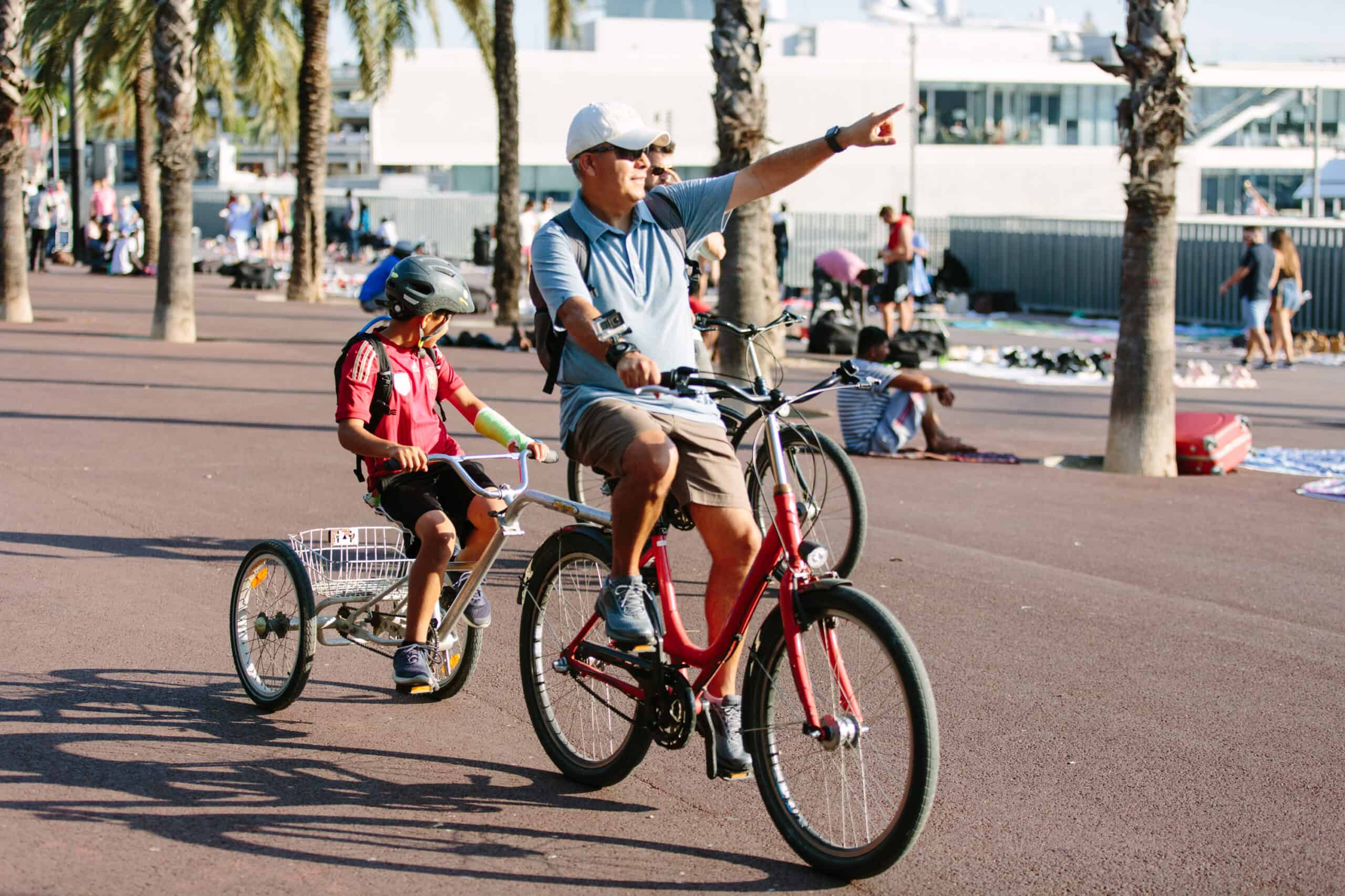 A father points out the beach to his son while riding a tandem bike in Barcelona, Spain