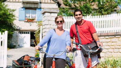 couple standing with their bikes in front of a traditional home in Giverny, France