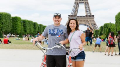 A couple poses with their bikes in front of the Eiffel Tower in Paris, France