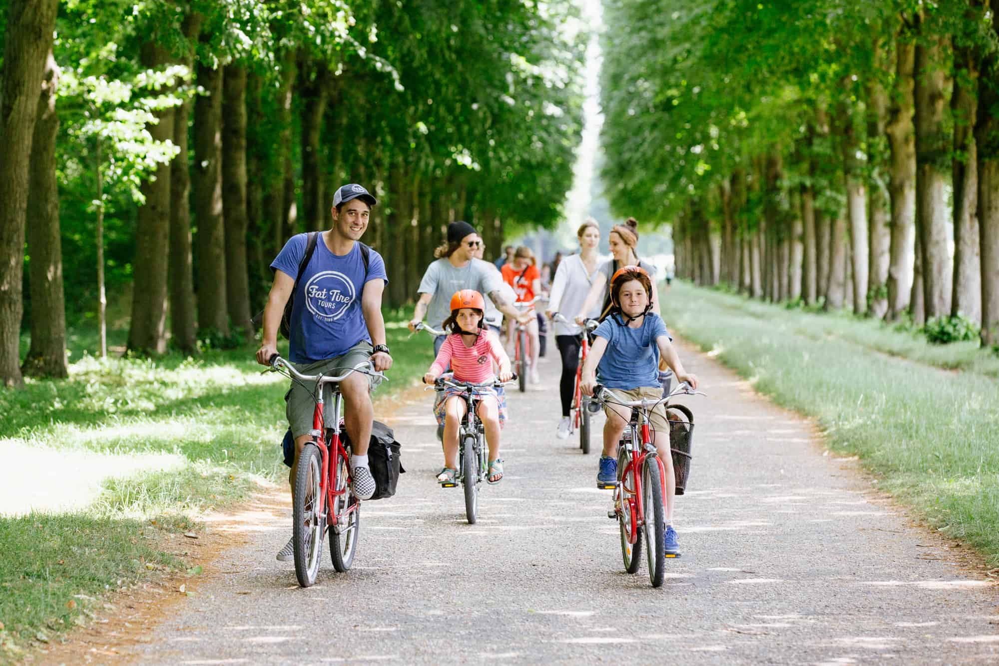 Two children ride at the front of the group alongside the guide during the Versailles Bike Tour.
