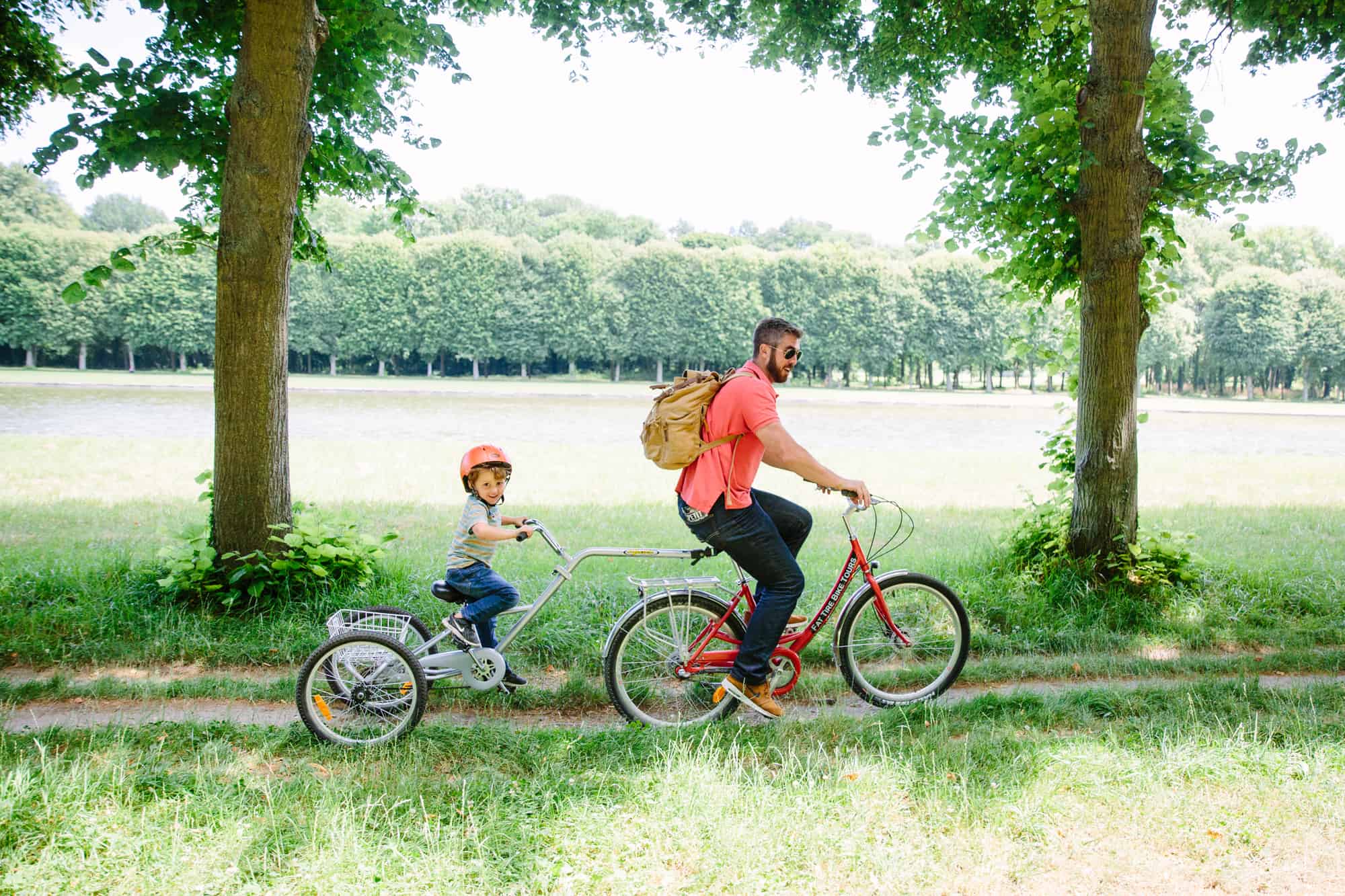 A father & son ride on a tandem bike during the Versailles bike tour.