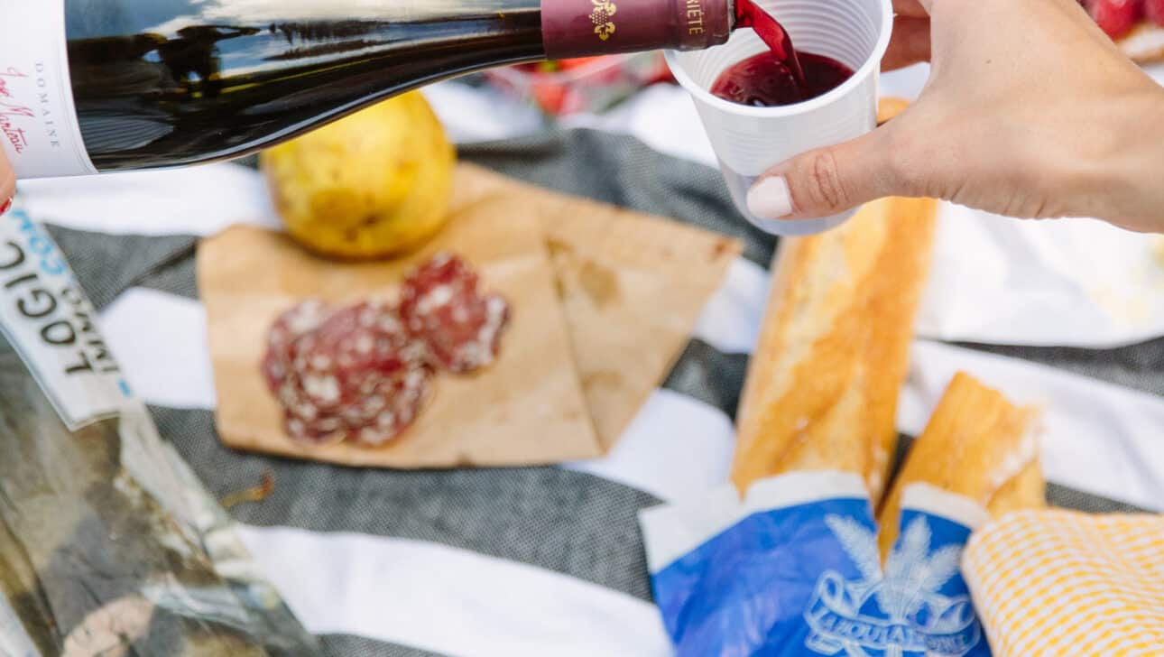 Red wine is poured at a picnic during the Versailles Bike Tour.