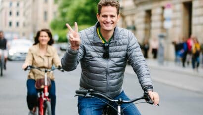 A Man gives the peace sign while riding through Berlin, Germany