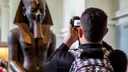 A man takes a photo of an Egyptian Mummy in the British Museum in London, England